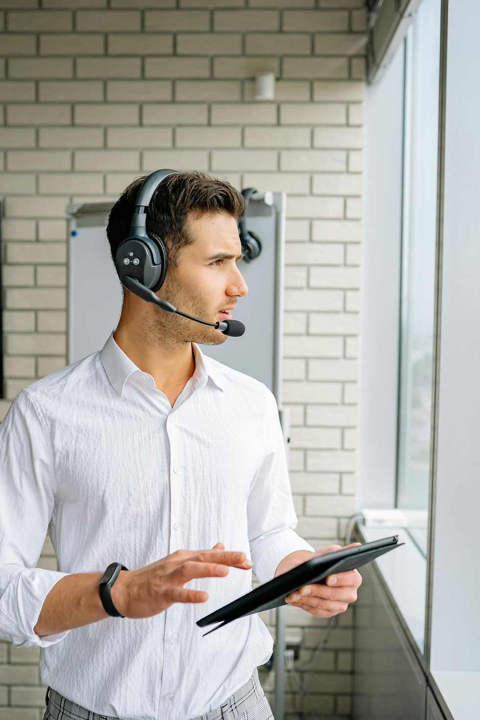 Customer support agent wearing a headset, using a tablet for AI chatbot automation and business communication.