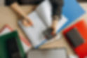 Businesswoman's hands on a desk with a calculator, notebook, pen, and office supplies, symbolizing financial planning and advisory