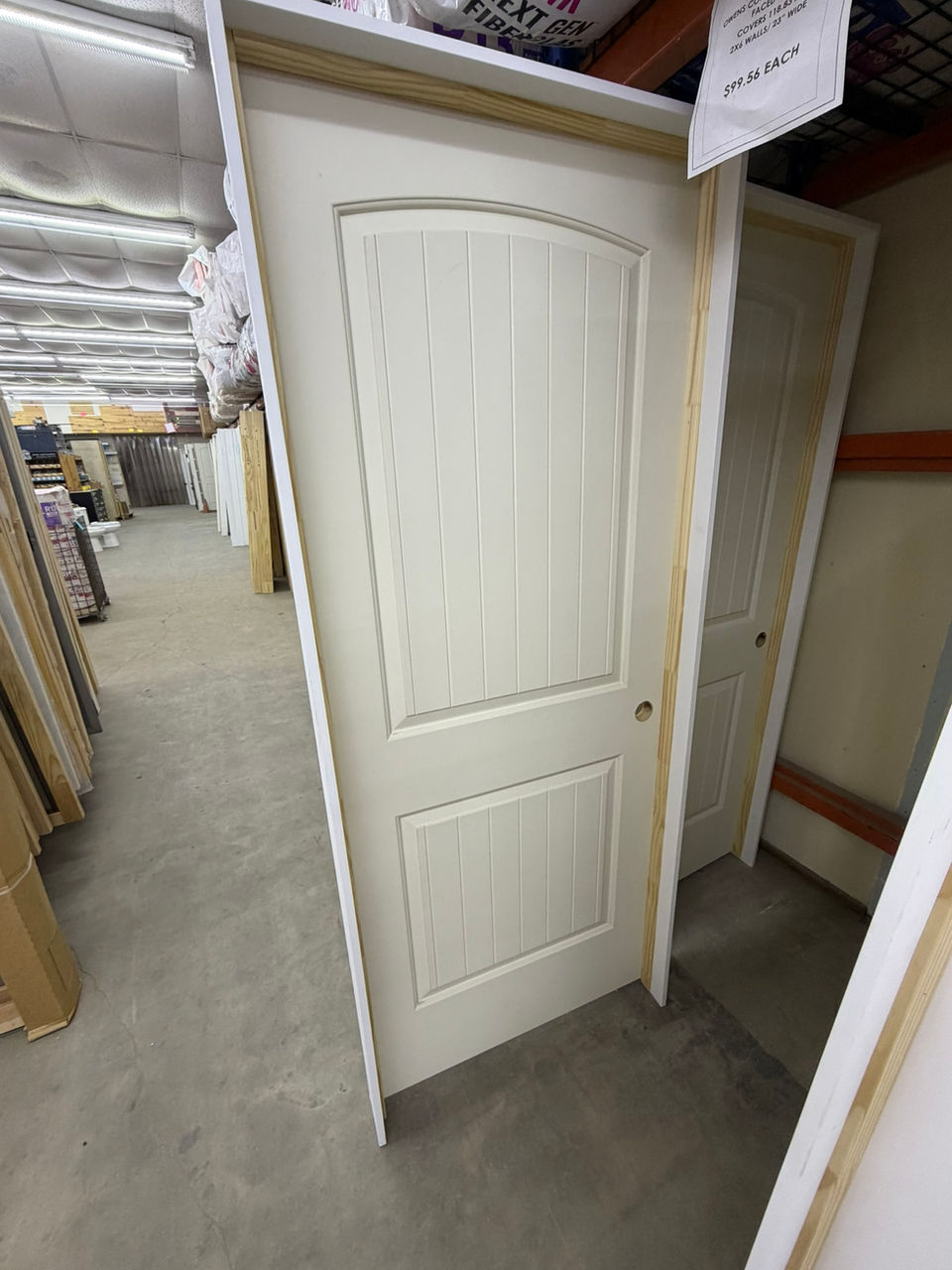 White arched two-panel interior door in a warehouse