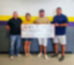 Four people hold a large check that says Edgewood ISD, DONATE, donation celebration.