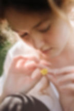 Дівчина тримає квітку пальчиками