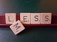 Scrabble-Buchstaben bilden das Wort Mess bzw. Less
