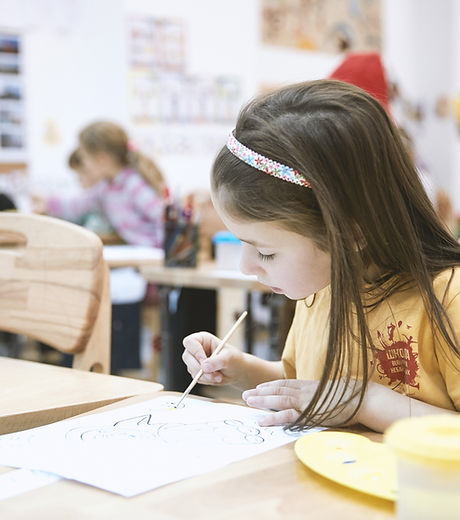 Child focused on painting a picture