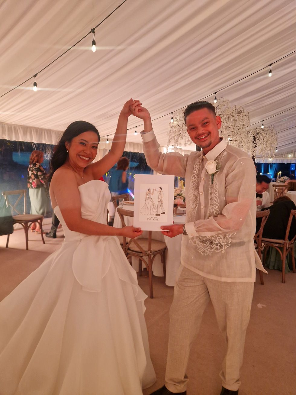 Bride and Groom holding their wedding painting created live at the wedding