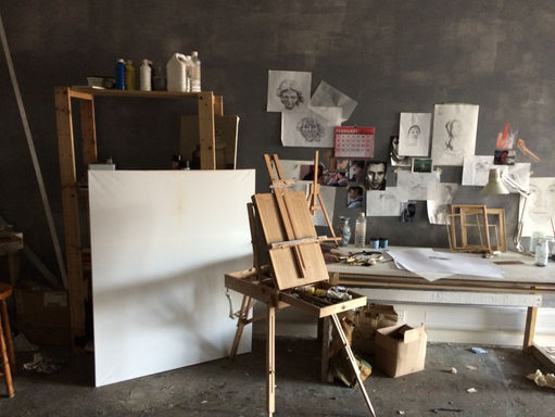Easel, canvas and lot of sketches in the studio