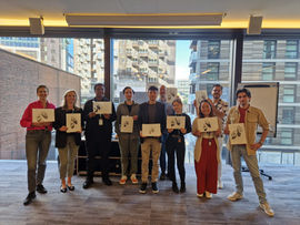 A group in an office holding their drawings up and smiling
