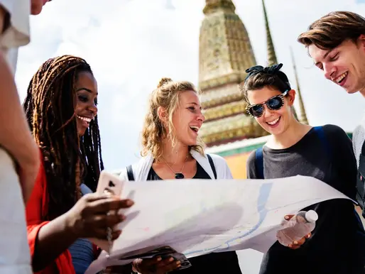 Des salariés profitent d’un voyage CSE, souriants, en train de lire une carte ensemble pour s’orienter lors d’une sortie organisée par leur comité d’entreprise