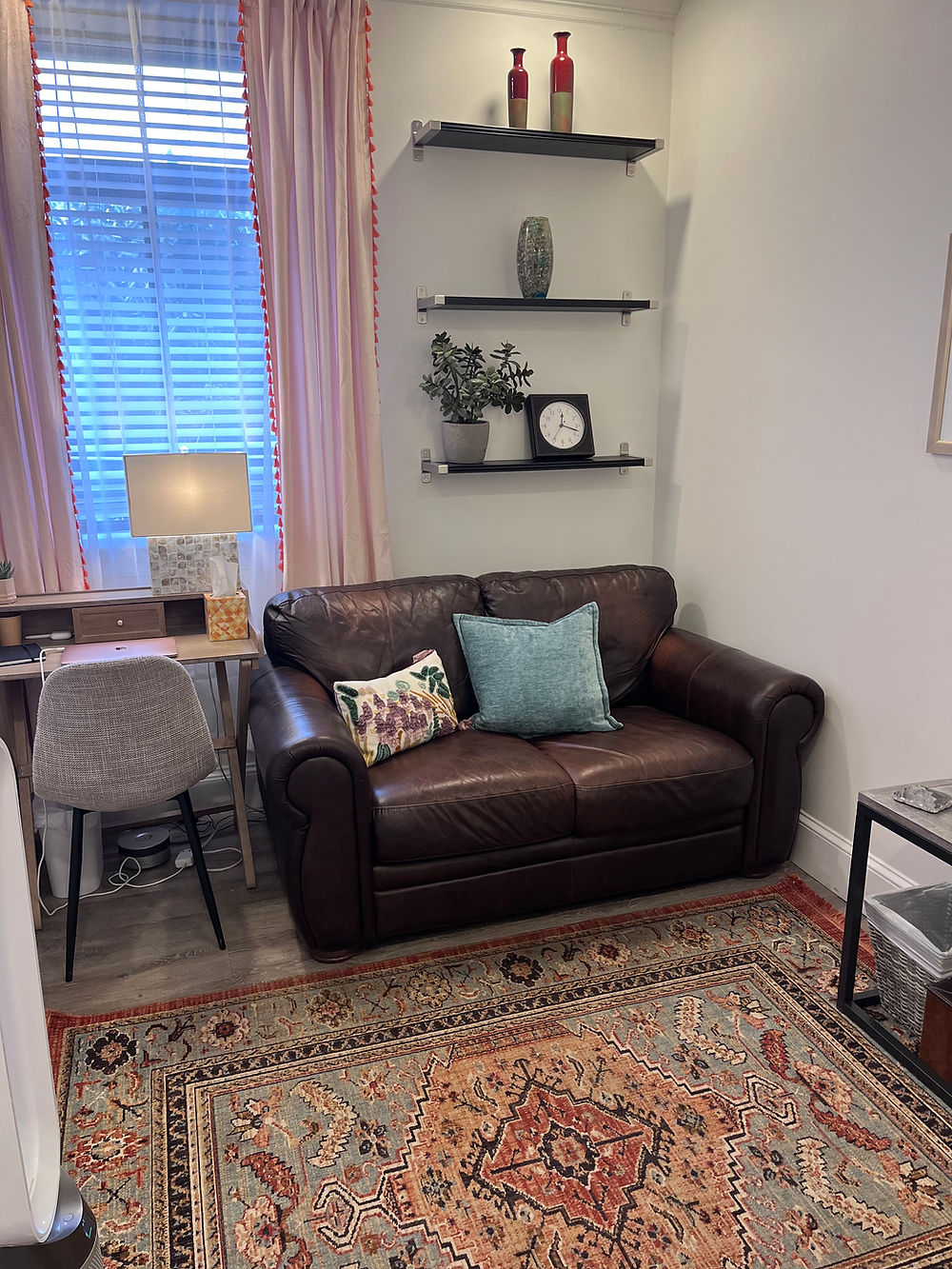therapy office with loveseat, therapist chair, and therapists desk