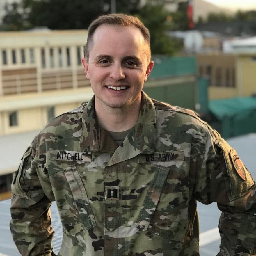 Tyler Mitchell in U.S. Army uniform, smiling, outdoor setting