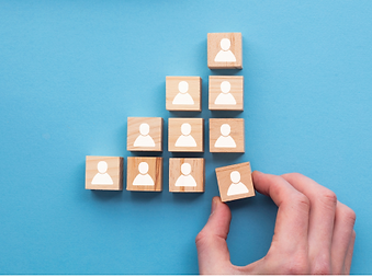Image of 10 blocks eith people on them with a hand moving the one on the bottom right