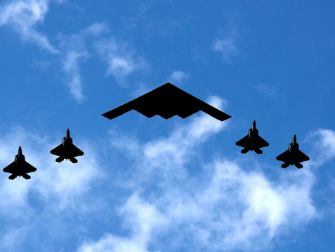 B-2 bomber jet with an escort of 4 additional fighter jets