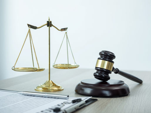 Waage, Richterhammer und Rechtsdokumente auf dem Schreibtisch