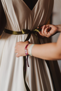 Eine weiße Person hilft einer Schwarzen Braut beim Ankleiden vor Hochzeit geplant von Hochzeitsplanerin Hessen. // A white person is helping a Black bride to get dressed before her wedding planned by wedding planner Hesse.