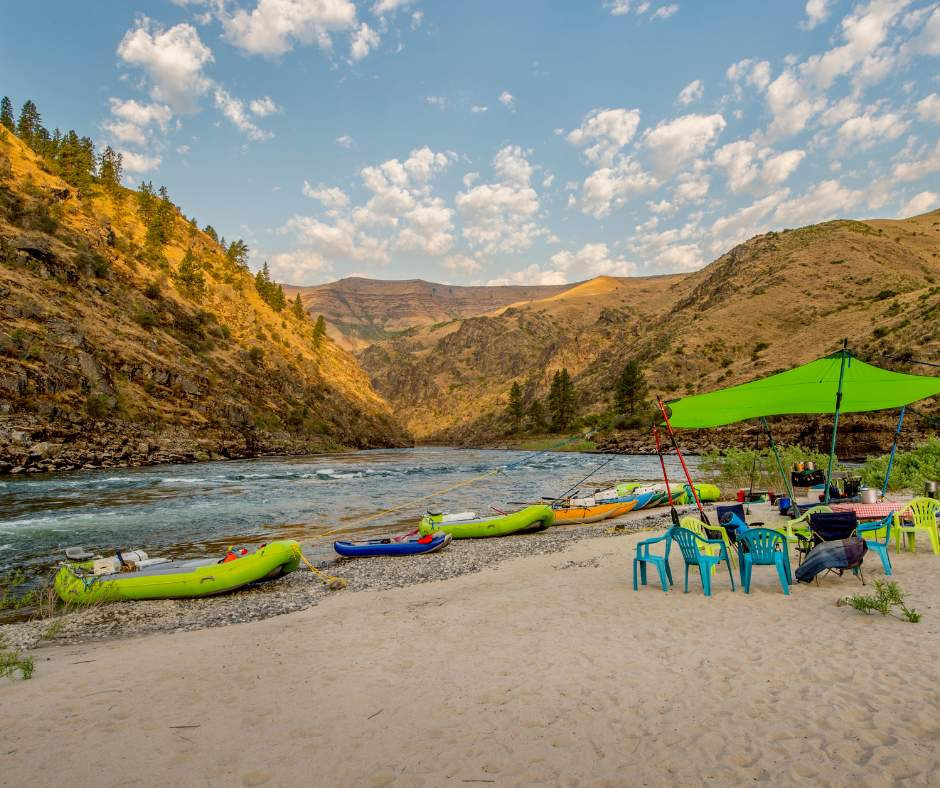 Photograph of a river running through mountains in Idaho with rafts on the shoreline
