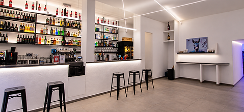 Sala del bar KM5 con bancone, bottigliera e sgabelli