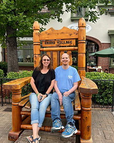 Shannon Wassam with a client smiling on a large wooden chair during a community outing.