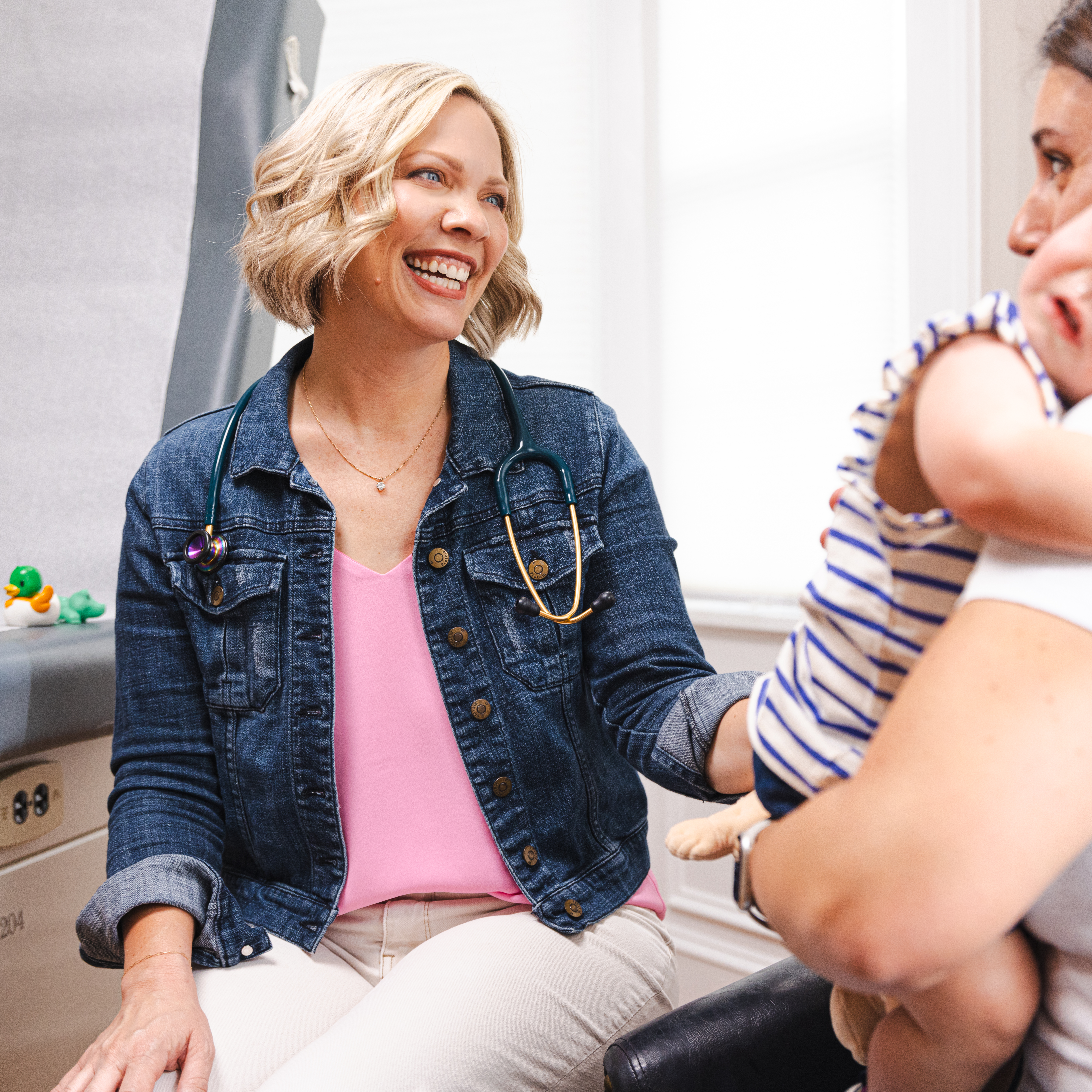 Female Pediatrician consults parent with child in doctor's office in Kingsport, TN
