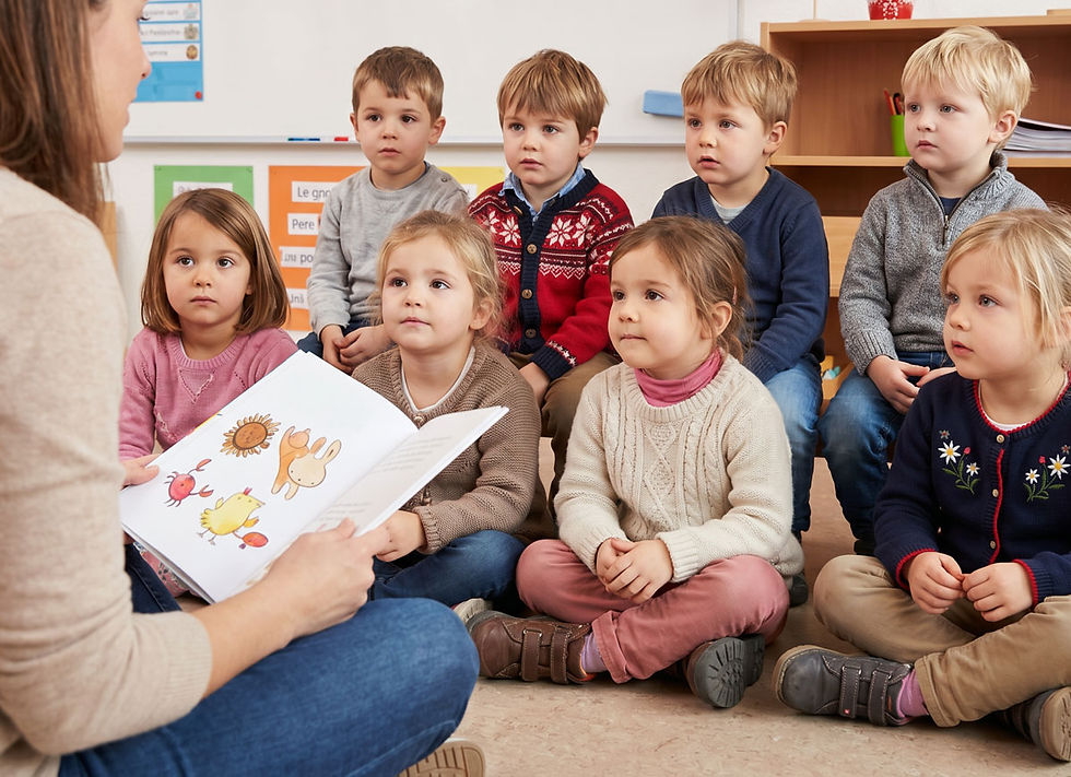 Eine Gruppe von Kindern, die ihrer Lehrerin beim Vorlesen zuhört