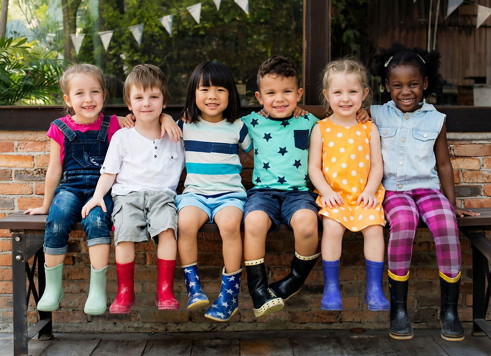 eine Gruppe von Kindern, die sich aneinander gekuschelt auf einer Bank sitzen