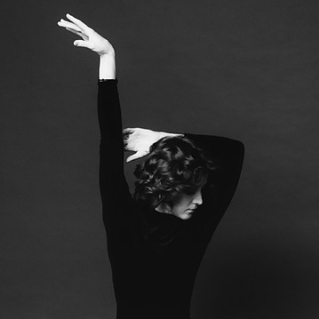 Dancer alone hands extended overhead