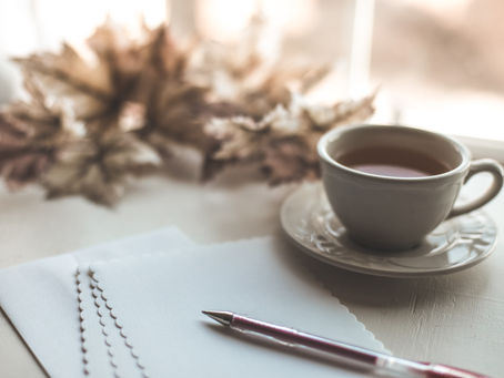 An open notebook on a sunny desk next to a coffee cup, illustrating a daily gratitude practice to reduce stress and train your brain away from negativity.