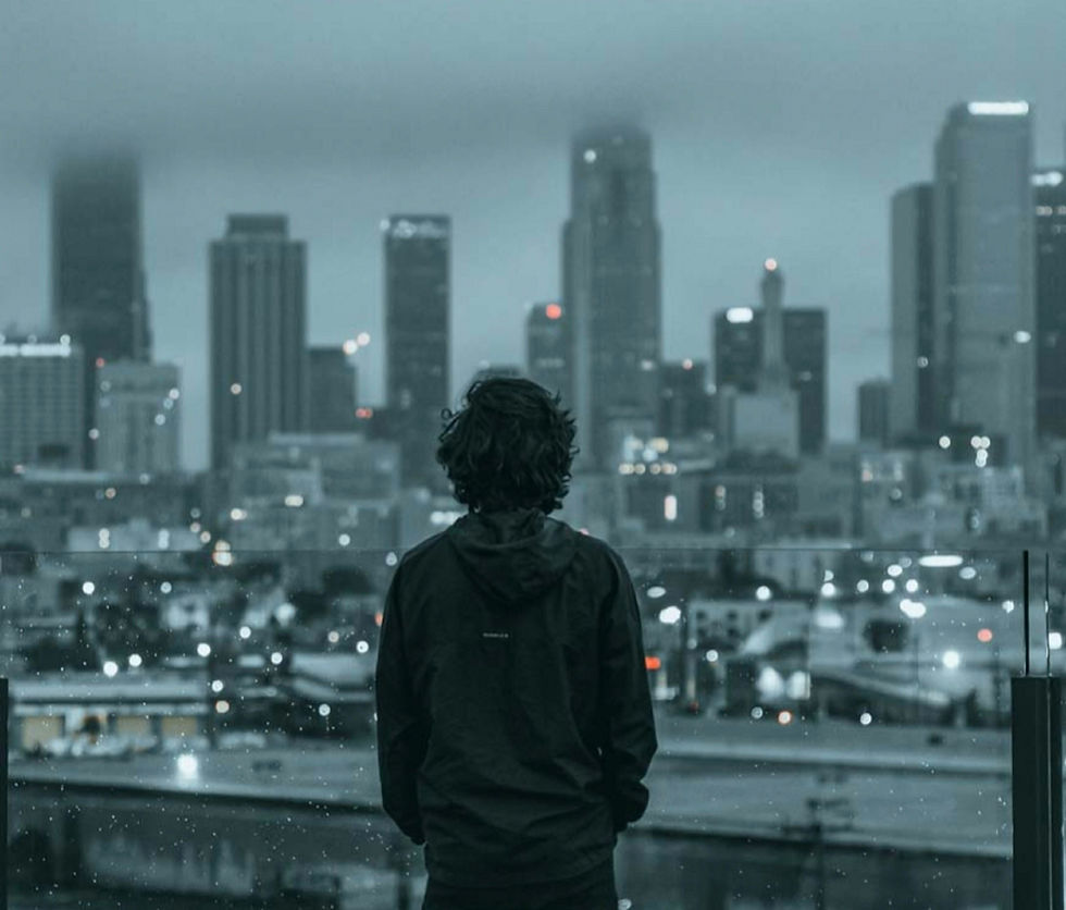 Stressed man looks into a a dark Manhattan skyline has hands in pockets | depression therapy in Manhattan, NY | therapist for depression | anxiety and depression | Midtown | Tribeca | Gramercy Park