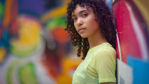 woman standing against graffiti wall