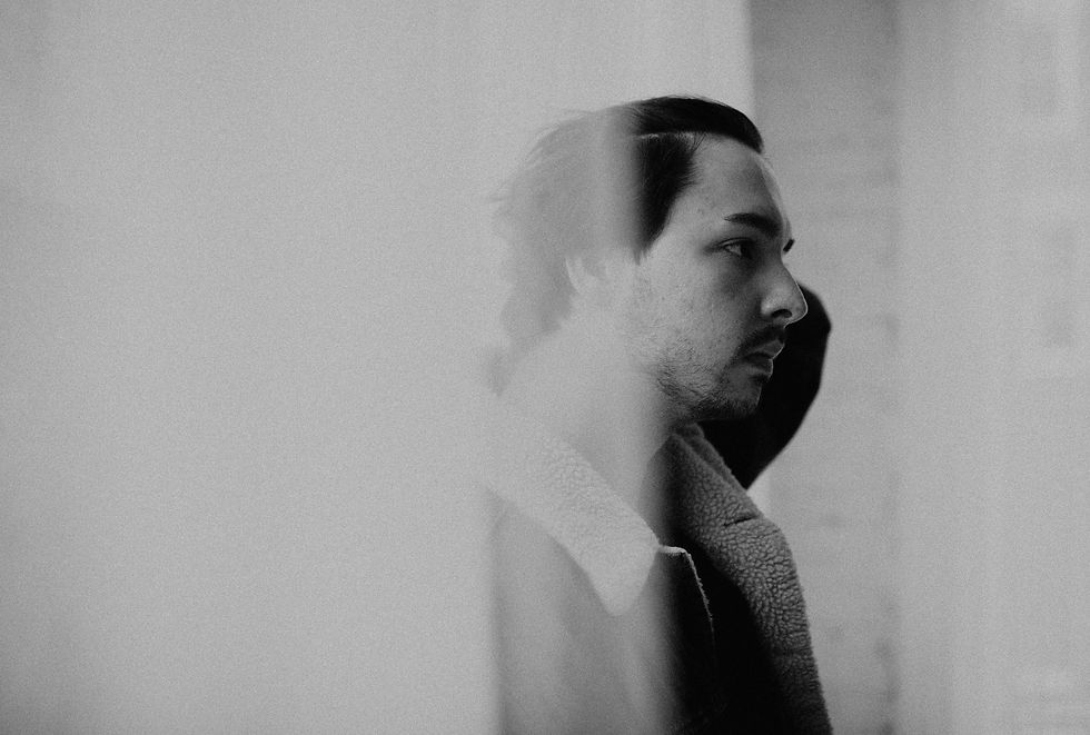 Black-and-white profile of a man with motion blur, looking right in a soft, hazy portrait.
