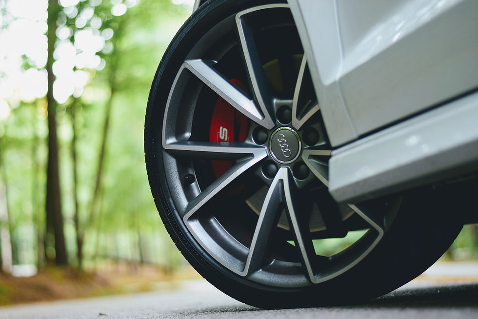 Close-up of a car tire and wheel on the road for a wheel alignment and tire alignment blog about uneven tire wear, pulling, and steering issues.