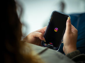 teen holding phone with meta logo