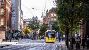 A Bee Network tram passing through Manchester city centre