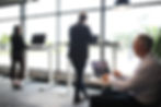 Anställda på ett kontor arbetar vid höj- och sänkbara skrivbord för att förbättra ergonomin och arbetsmiljön