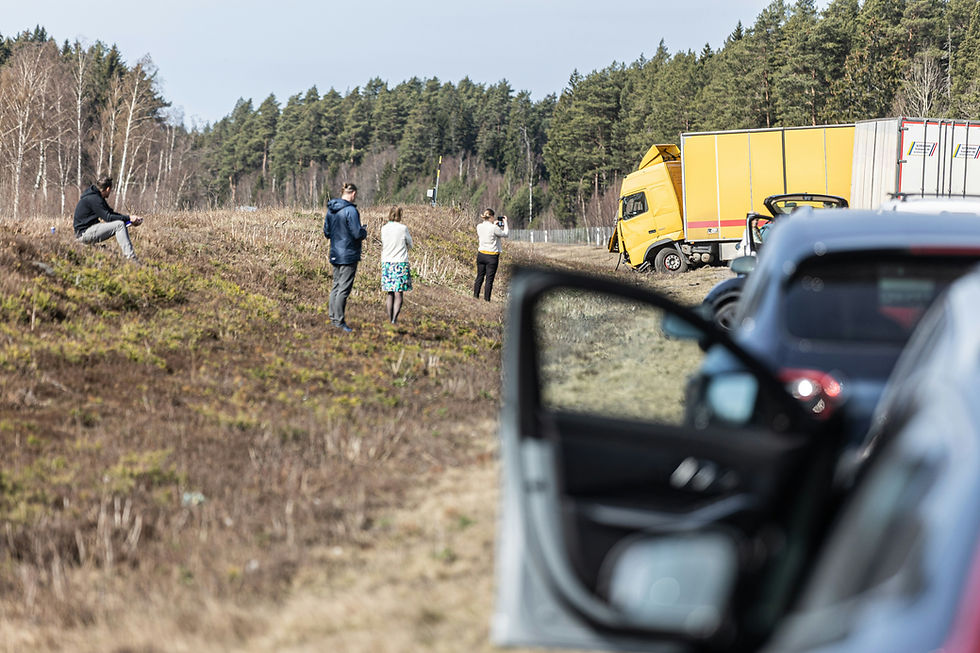 People standing near the scene of a car and commercial truck collision