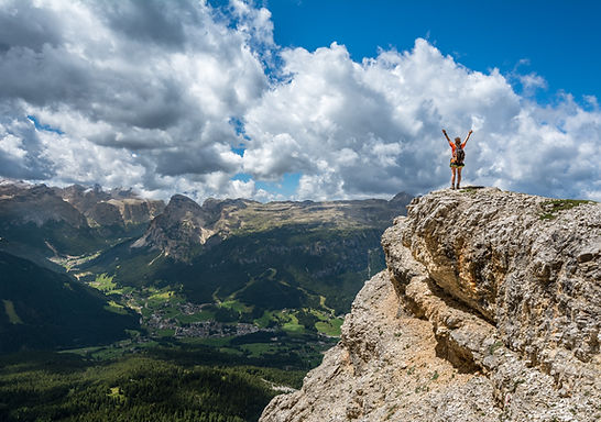 Man celebrating sucessfully reaching mountain summit.