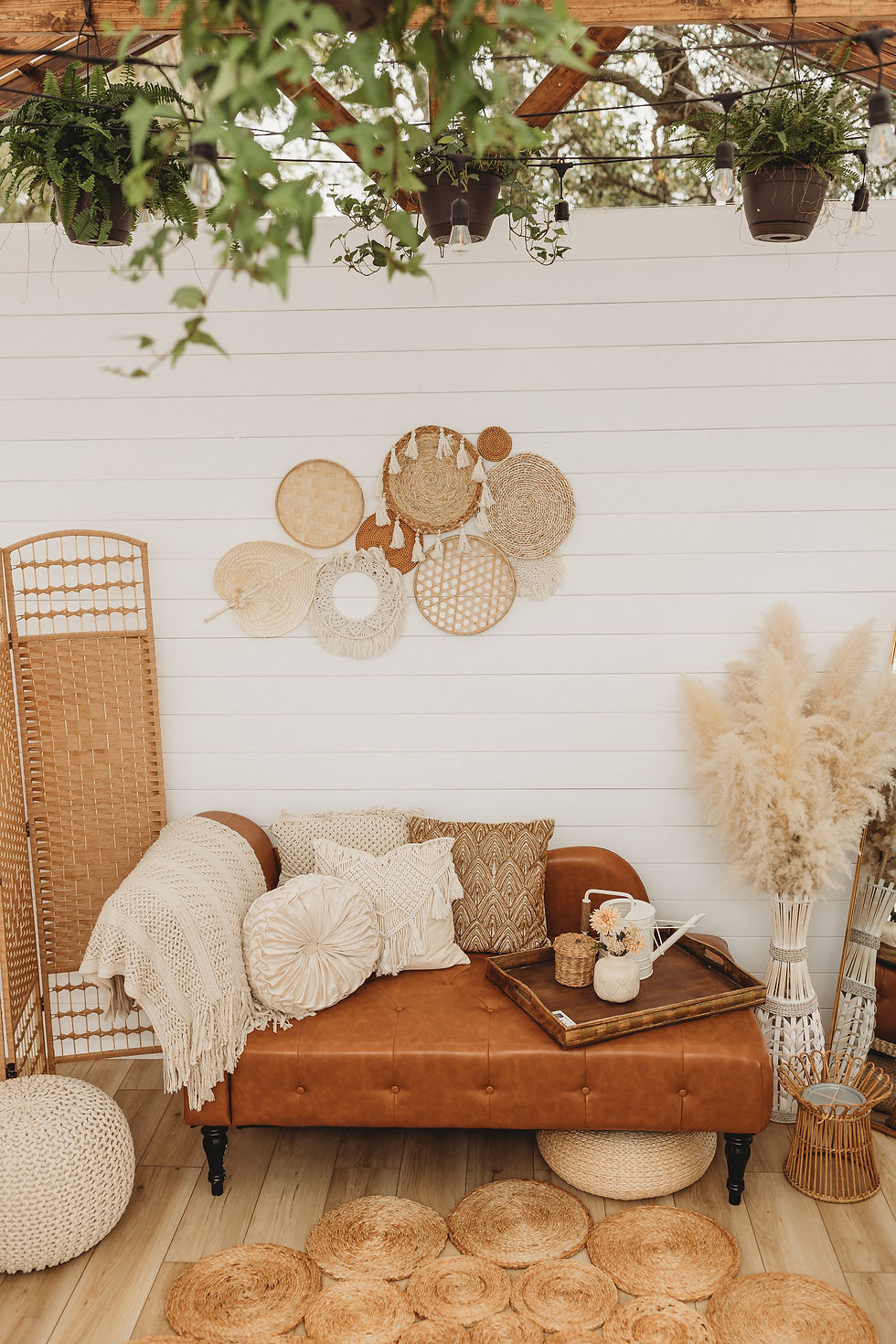 Boho style room showing layering techniques with pillows and hanging baskets and plants. 