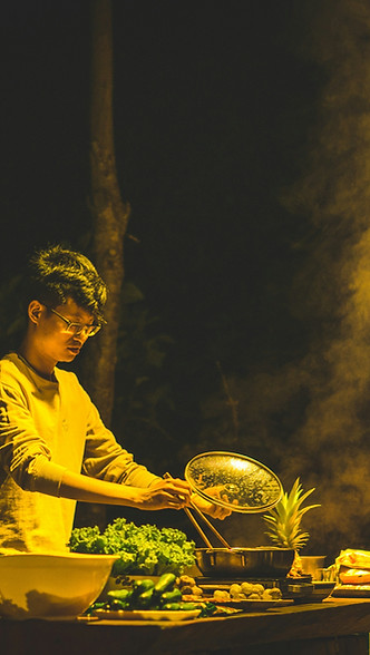 A chef adds vegetables to a hotpot dish. Image by Tien Vu Ngoc.