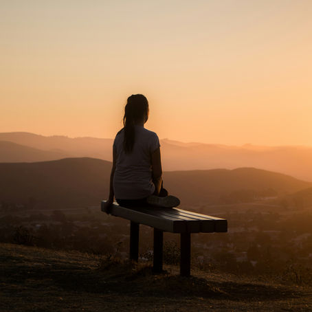 Person sitting on a bench contemplating childhood emotional neglect