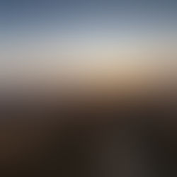 Mountain landscape at sunrise with a gravel path, wooden fences, and misty valleys. Warm orange and purple hues create a serene mood.