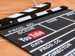 YouTube logo on a bright screen above a glowing keyboard in a dark room, creating a sleek, techy mood