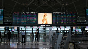 aeroporto com painel de voos e pessoas andando