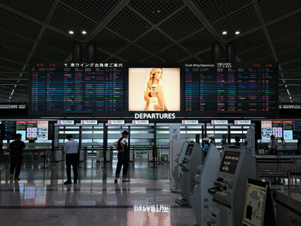 aeroporto com painel de voos e pessoas andando