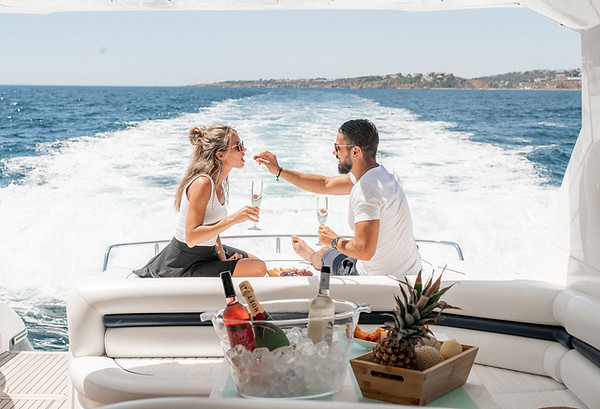 A couple enjoying a drink on the back of a motor yacht