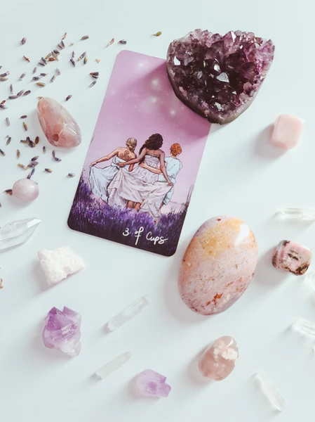 three of cups tarot card surrounded by crystals and lavender