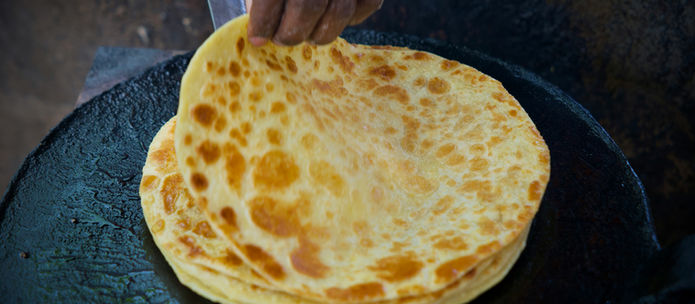 Fresh homemade chapati being cooked on a pan, representing natural carbohydrate foods discussed in this guide to carbohydrates, weight loss and healthy eating.