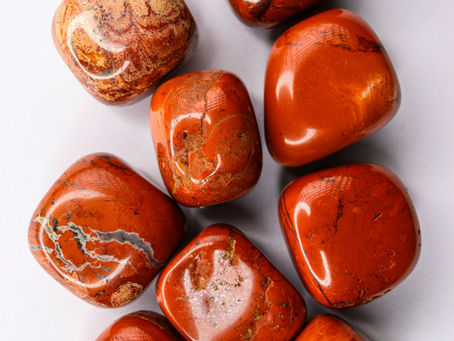 an image of red jasper tumbles crystals set out on a table
