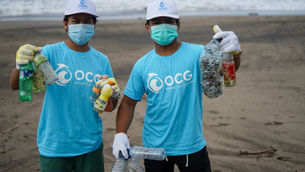 Pair of volunteers cleaning up trash on the beach