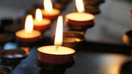 Bougies allumées alignées, créant une ambiance chaleureuse et recueillie pour un moment de recueillement