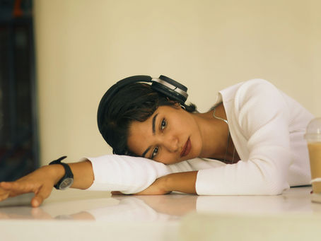 Woman sitting at a table with her arm and head resting on the table looking worried.