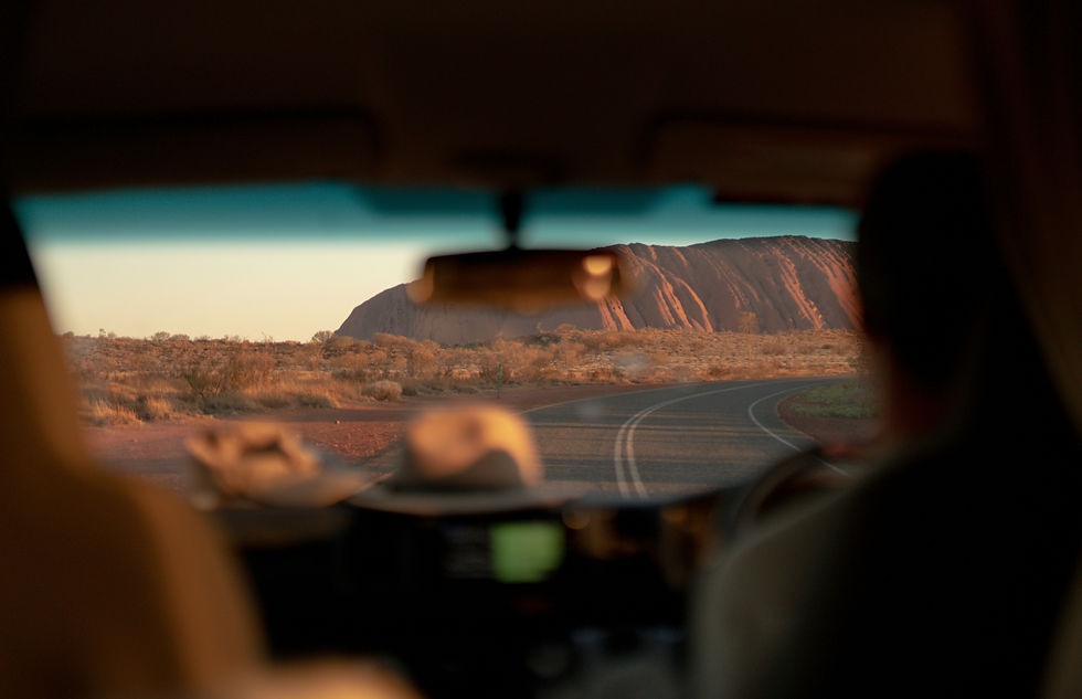View of Uluru from a car on a Red Centre travel guide trip. Image by Mitch