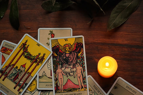 tarot cards on a mahogany table with a candle
